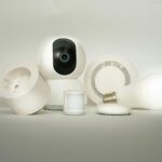 A collection of smart home devices, including a camera, light bulb, and sensors, on display.