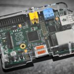 Detailed image of a Raspberry Pi microcomputer circuit board in a clear case.